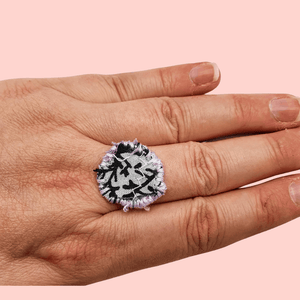A circle fabric ring in pink and black fabric with lilac decorative stitching around the edge.