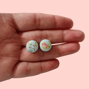 Delicate blue floral fabric studs.