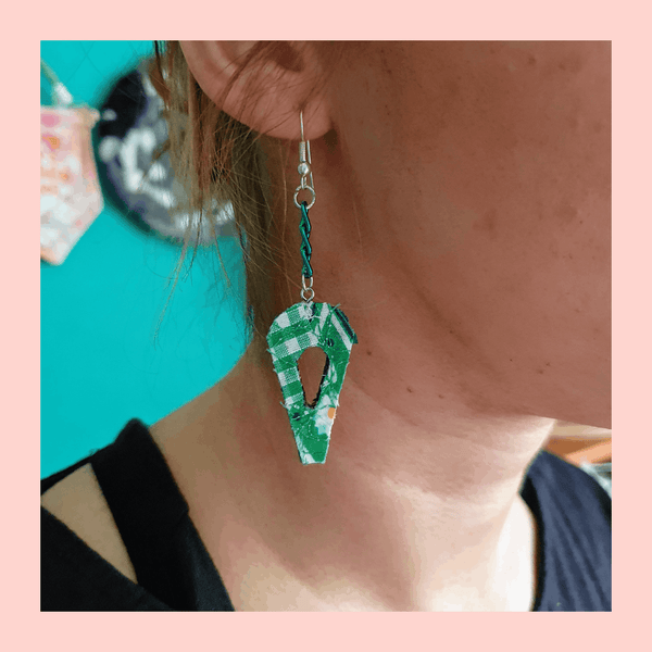 Dangle earrings with green chain in an abstract leaf design.