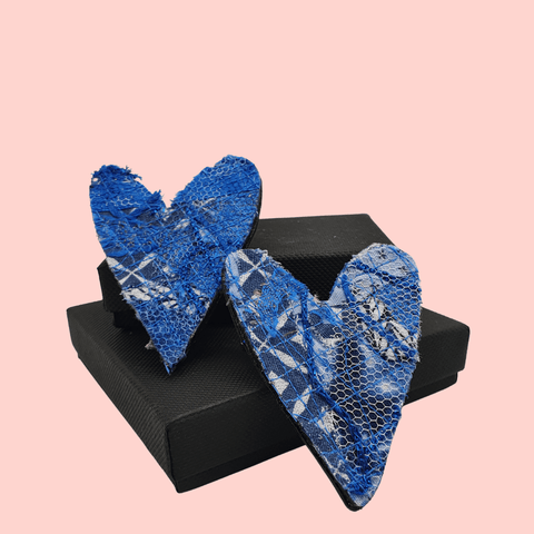two heart shaped fabric brooches created using scrap fabrics. blues with a black back.