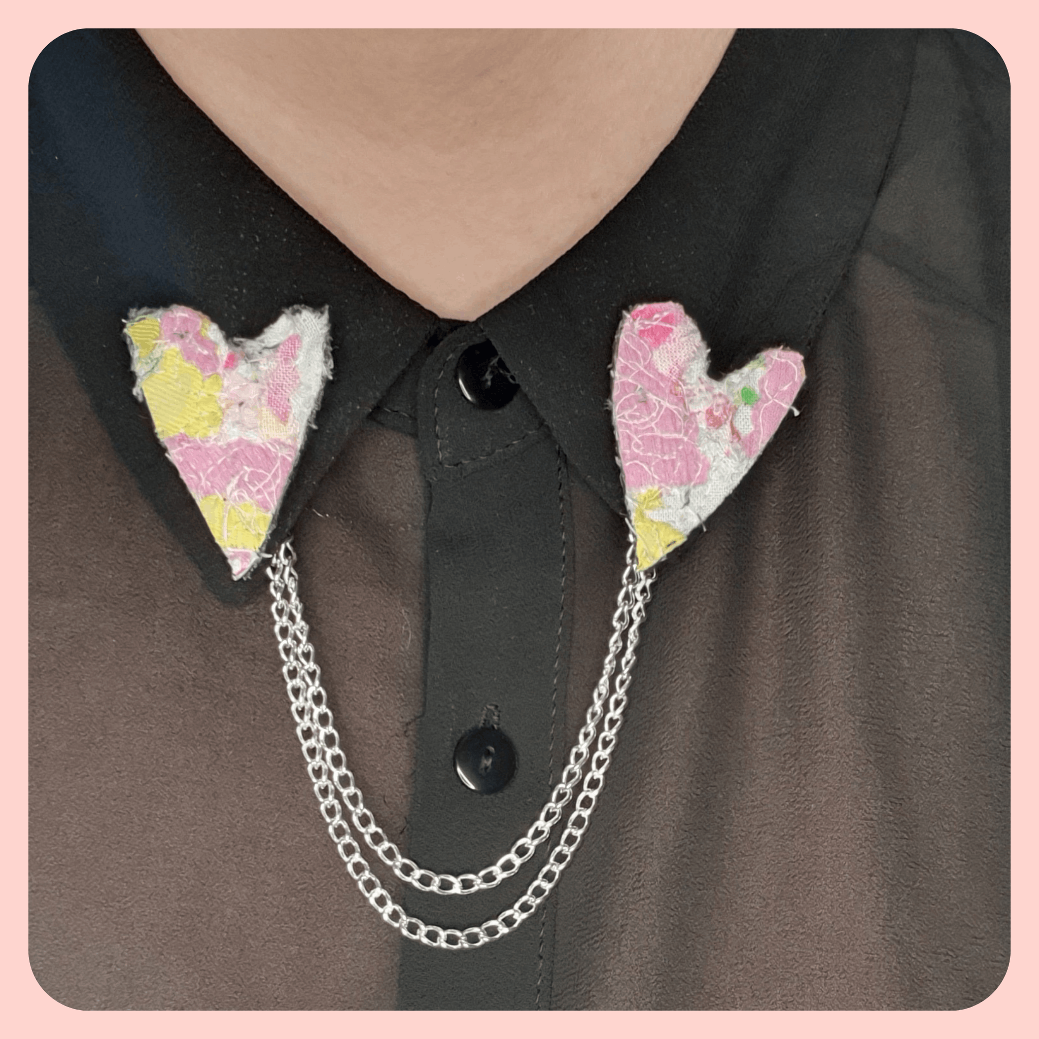 Pink and yellow collar pins worn on a black shirt