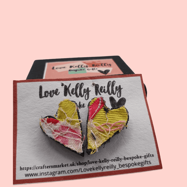 a pair of small heart shaped stud earrings. pink and yellow textile created with scraps of fabric. 