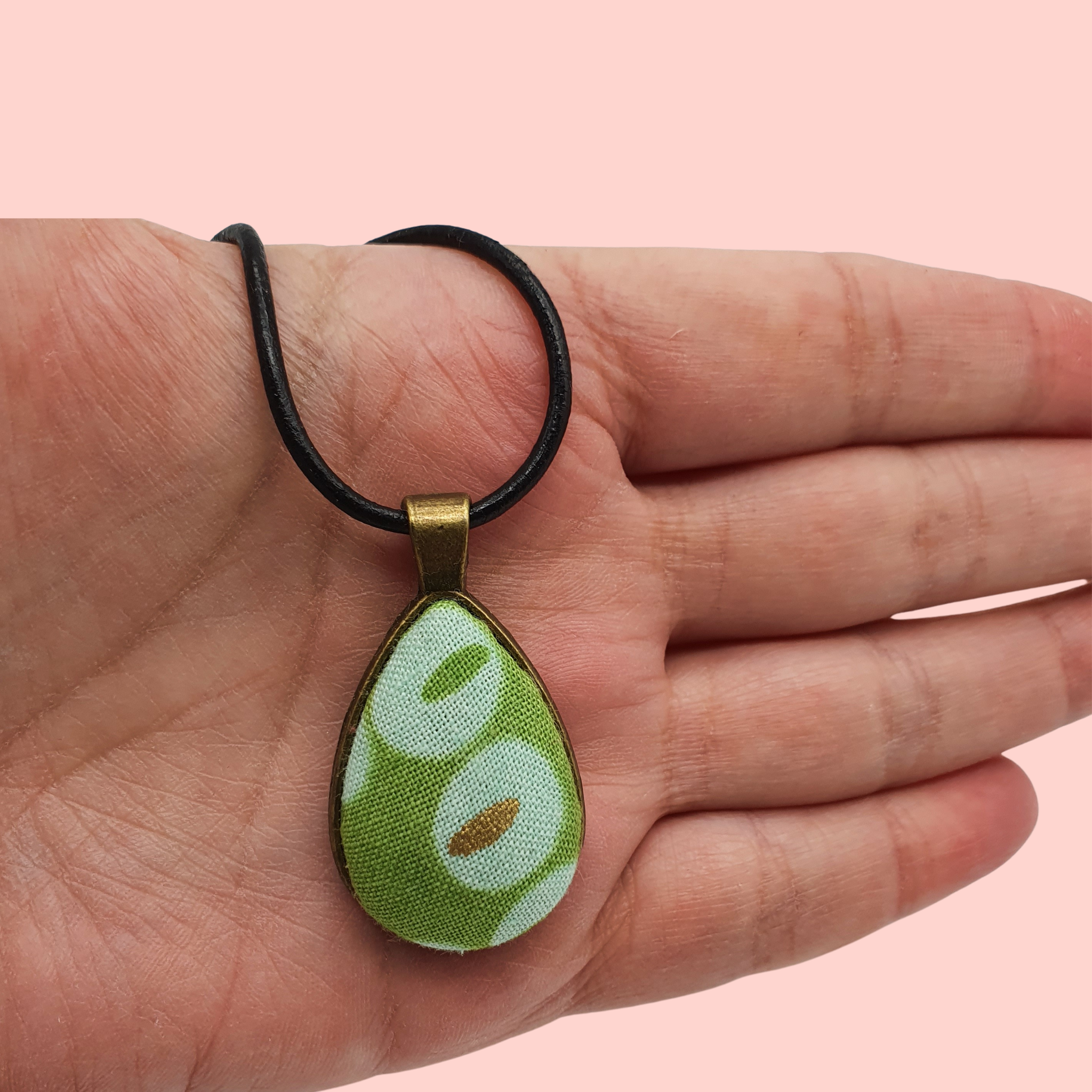 Green circle and spotty design fabric in a teardrop bronze bezel pendant.