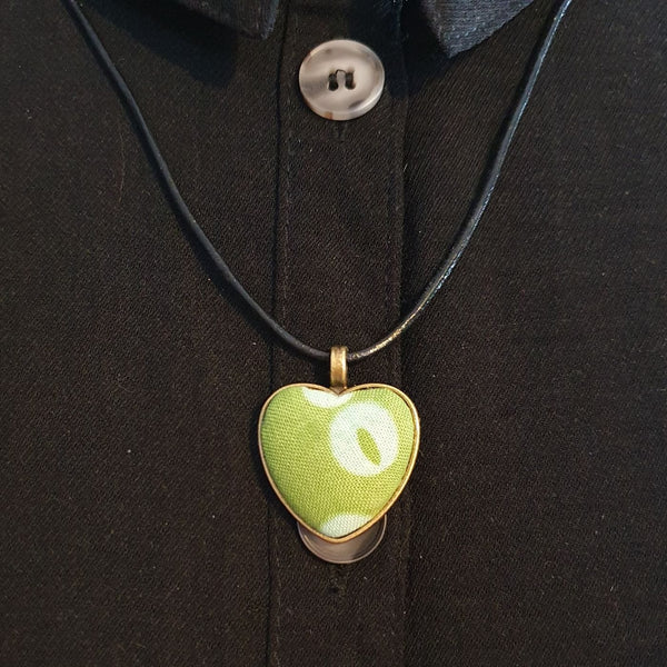 Green circle and spotty design fabric in a heart bronze bezel pendant.