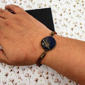 Blue fabric with a gold flower design bracelet.