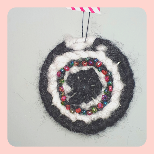 Mini black and white abstract weaving with circle beaded detail.