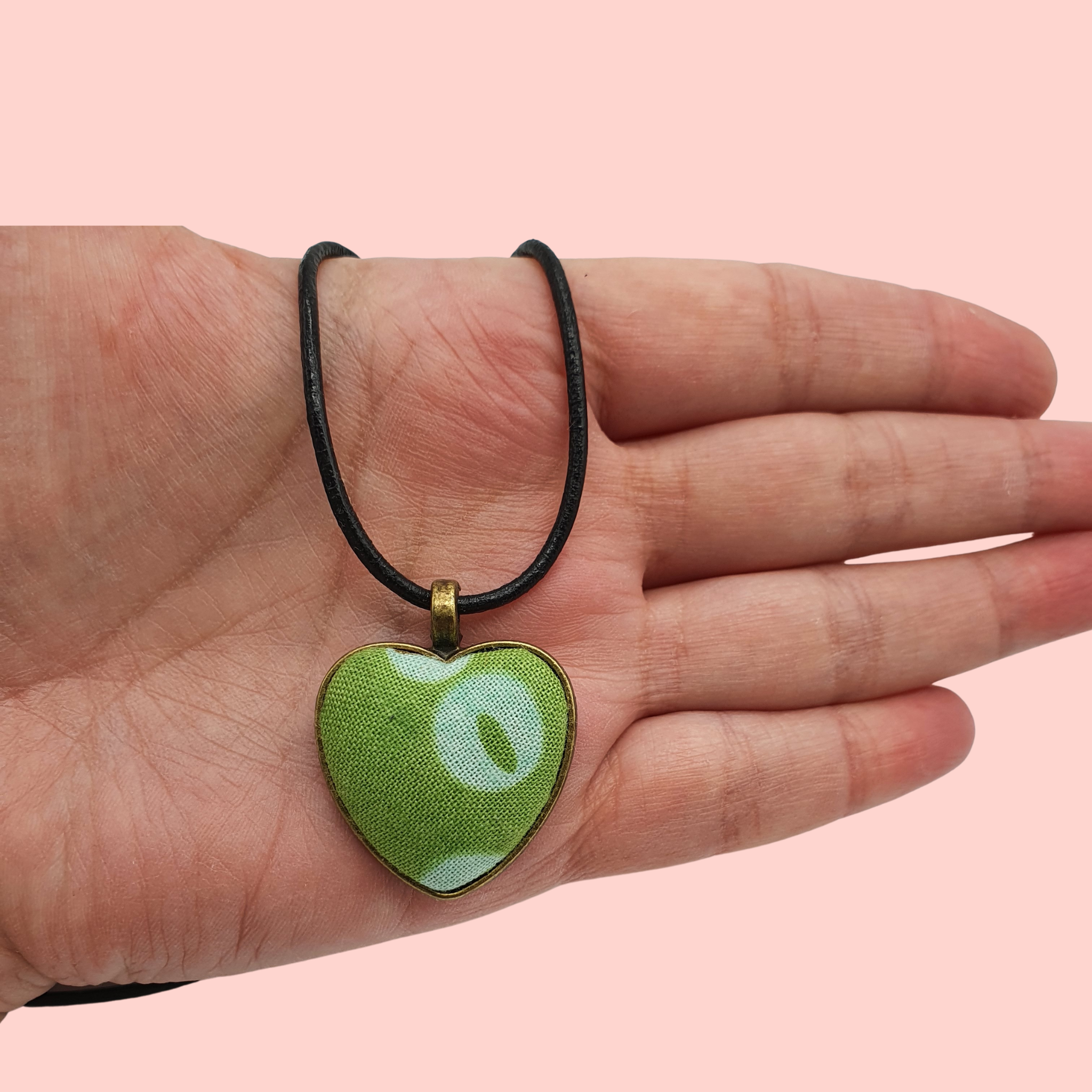 Green circle and spotty design fabric in a heart bronze bezel pendant.
