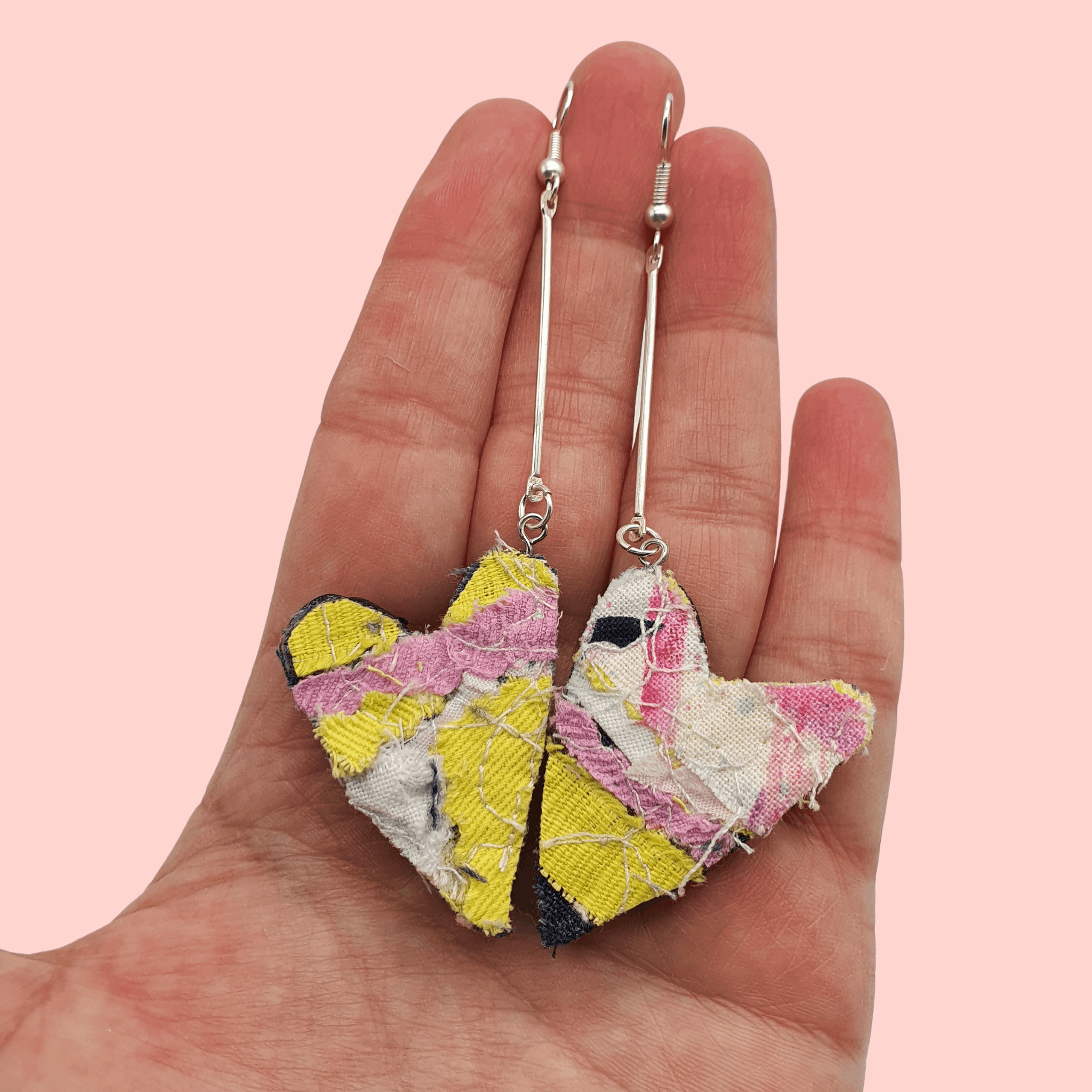 Heart shaped pink and yellow dangle earrings with a silver plated bar.