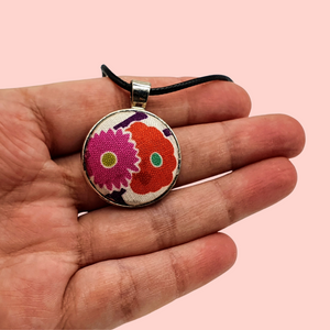 Fabric covered cobochon style circle pendant.