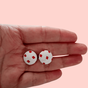 Red diamond pattern on white fabric button studs.