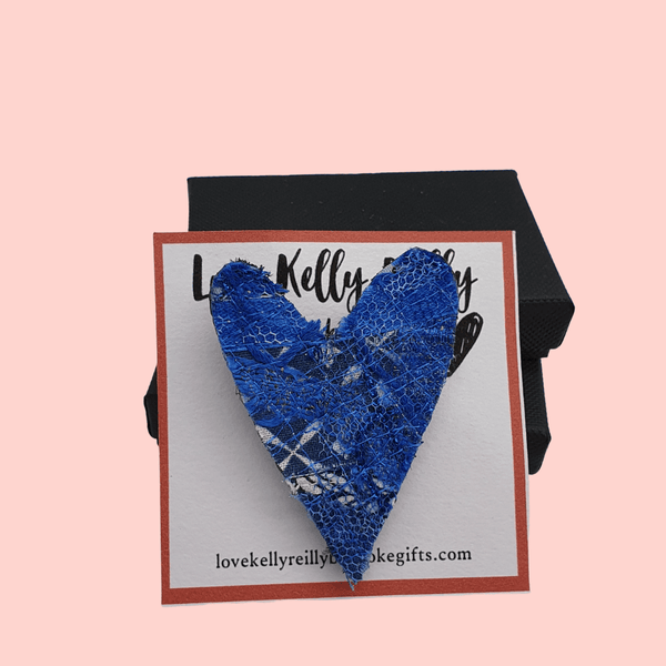 Two heart shaped fabric brooches created using scrap fabrics. blues with a black back.